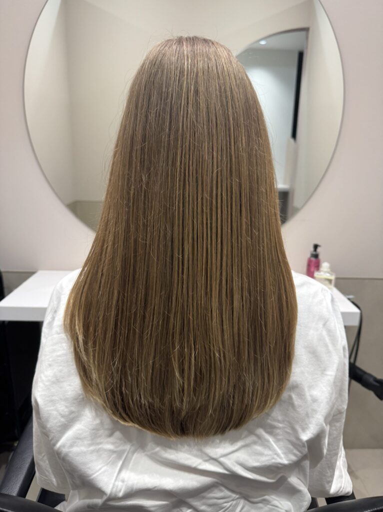 Long light-brown hair with smooth, healthy ends after a haircut — straight back view