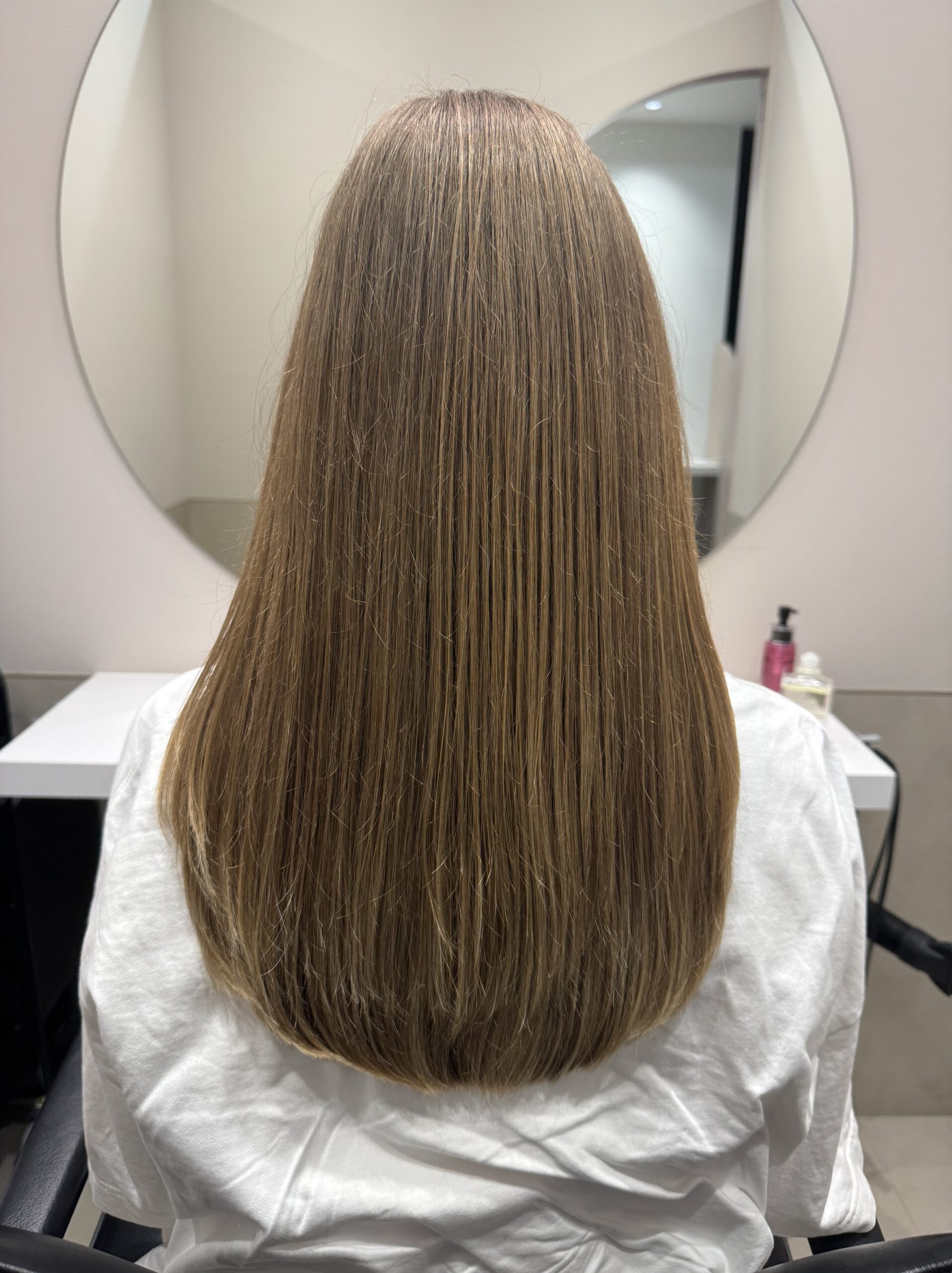Long light-brown hair with smooth, healthy ends after a haircut — straight back view