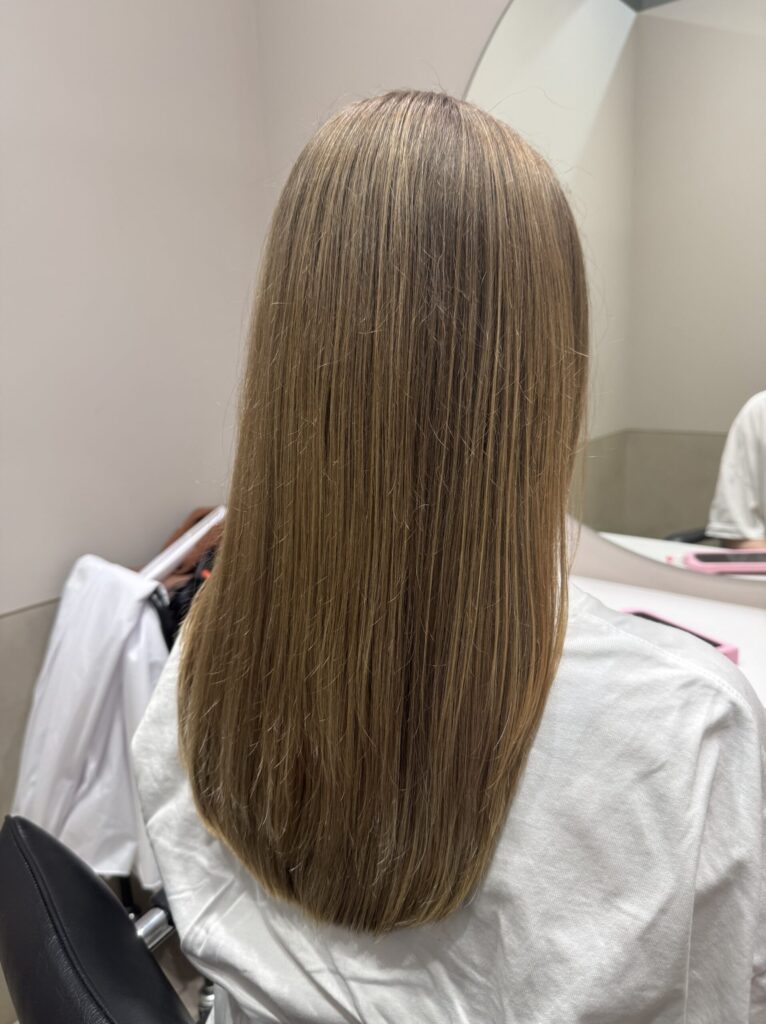 Side view of long light-brown hair falling naturally after a haircut