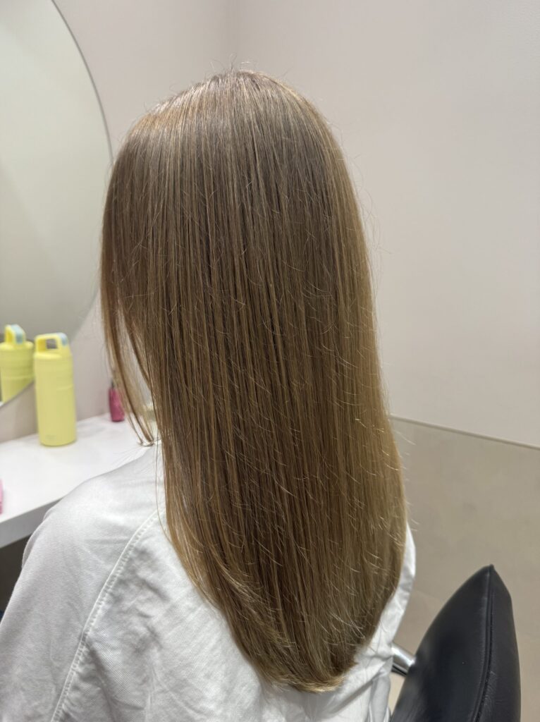 Side-back view of long light-brown hair with soft, rounded ends after a trim