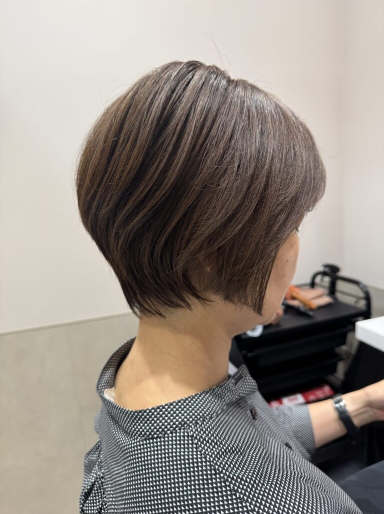 Short bob haircut with a soft rounded silhouette and glossy natural brown color, side view